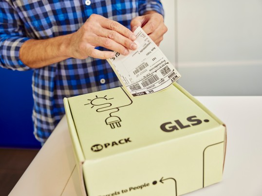 Mann-klebt-Etikett-auf-GLS-Paket
