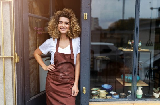 Young lady smiling in front of her shop